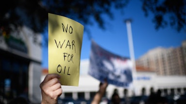 A protester holds up a sign that says, "No war for oil"