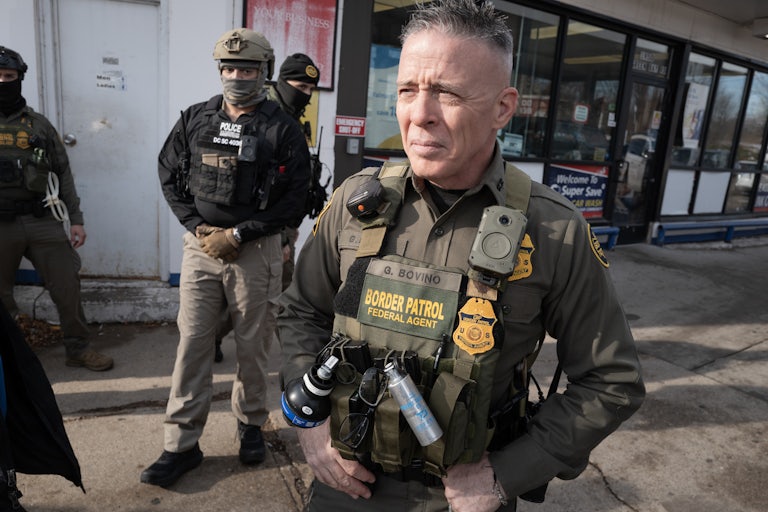 CBP Chief Gregory Bovino stands with masked agents outside a gas station store