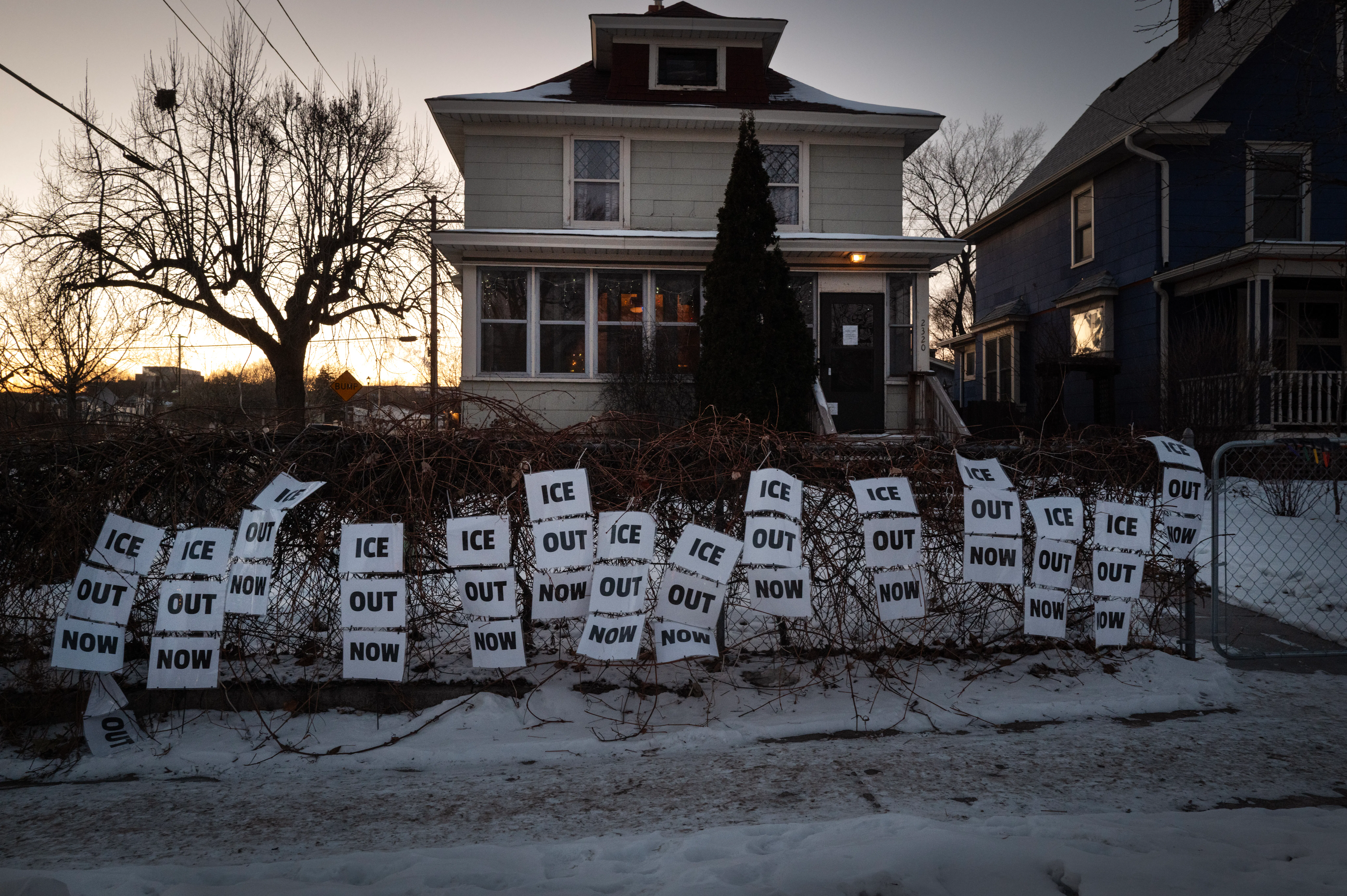 Dozens of signs reading "ICE Out Now" decorate the front of a Minneapolis home 