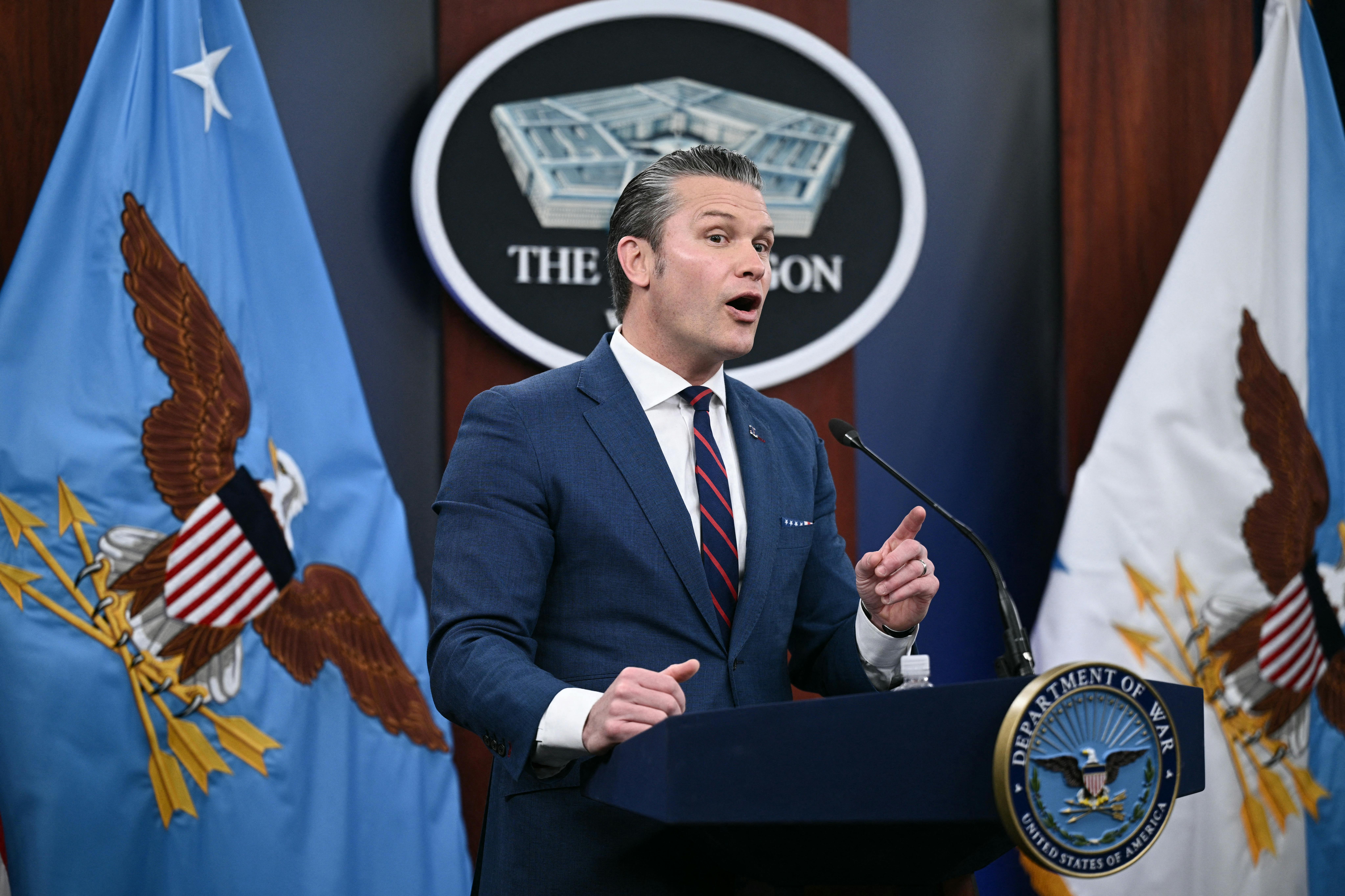 Defense Secretary Pete Hegseth gestures and speaks at a podium