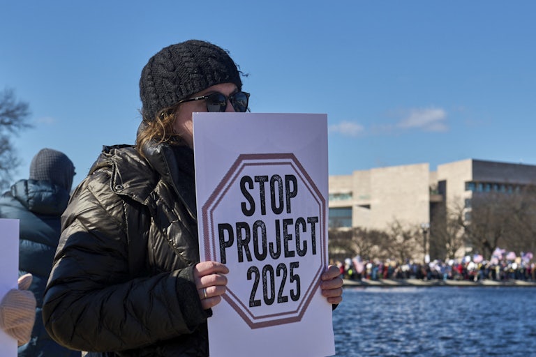 A person holds up a sign that says, "Stop Project 2025" during a protest outside the Capitol