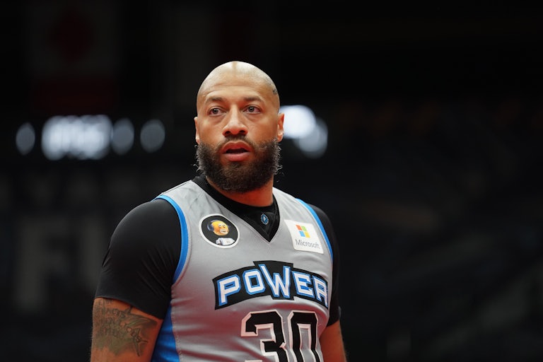 Retired NBA player Royce White stands on basketball court.