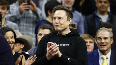 Elon Musk claps as Donald Trump enters the stadium during the Division I Men’s Wrestling Championship at the Wells Fargo Center.