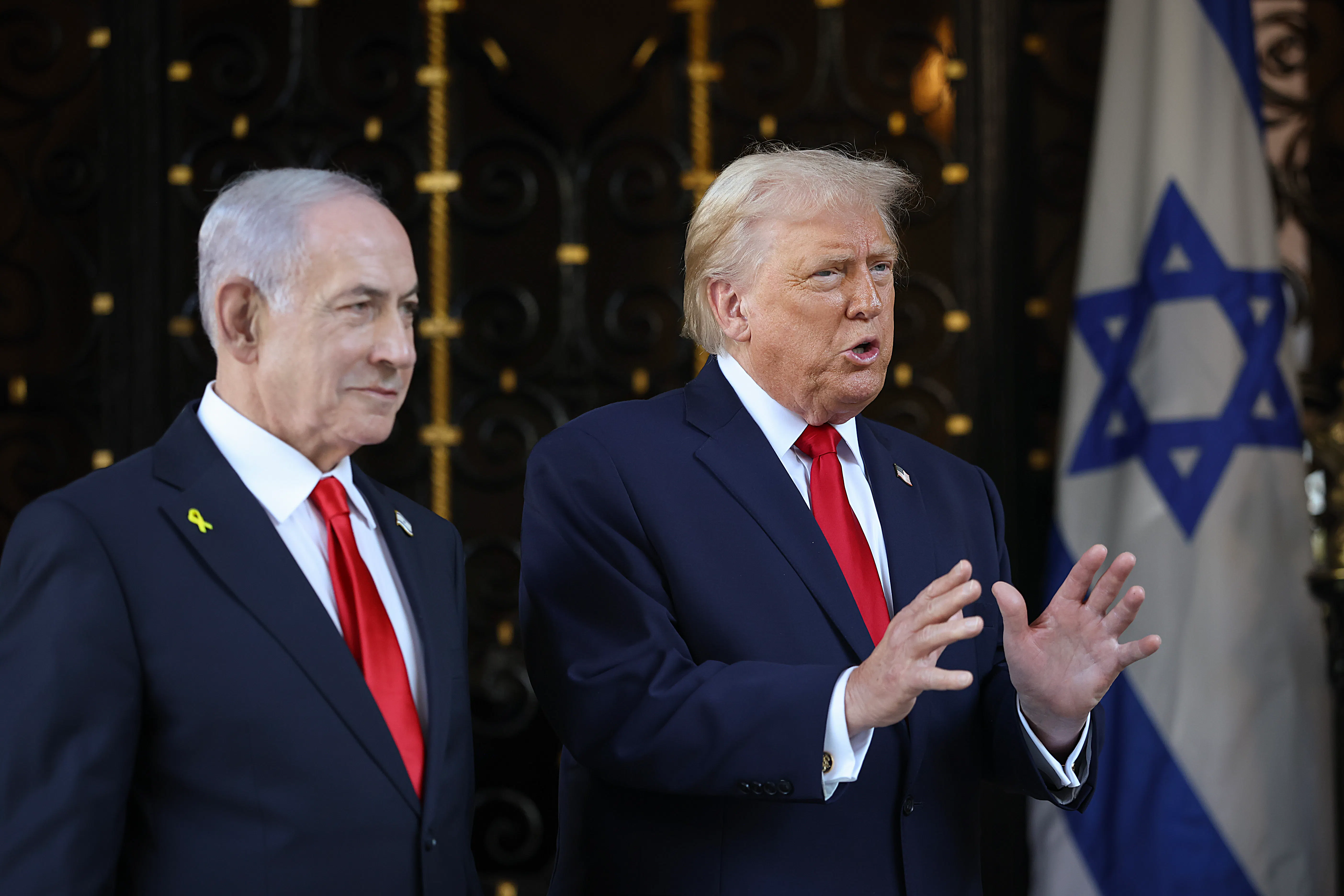 Donald Trump gestures and speaks while standing next to Israeli Prime Minister Benjamin Netanyahu