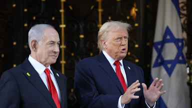 Donald Trump gestures and speaks while standing next to Israeli Prime Minister Benjamin Netanyahu
