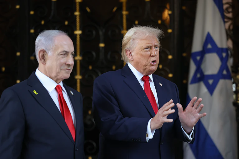 Donald Trump gestures and speaks while standing next to Israeli Prime Minister Benjamin Netanyahu