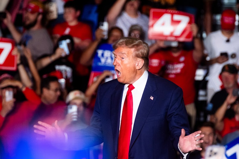 Donald Trump holds his hands out while speaking at a campaign rally