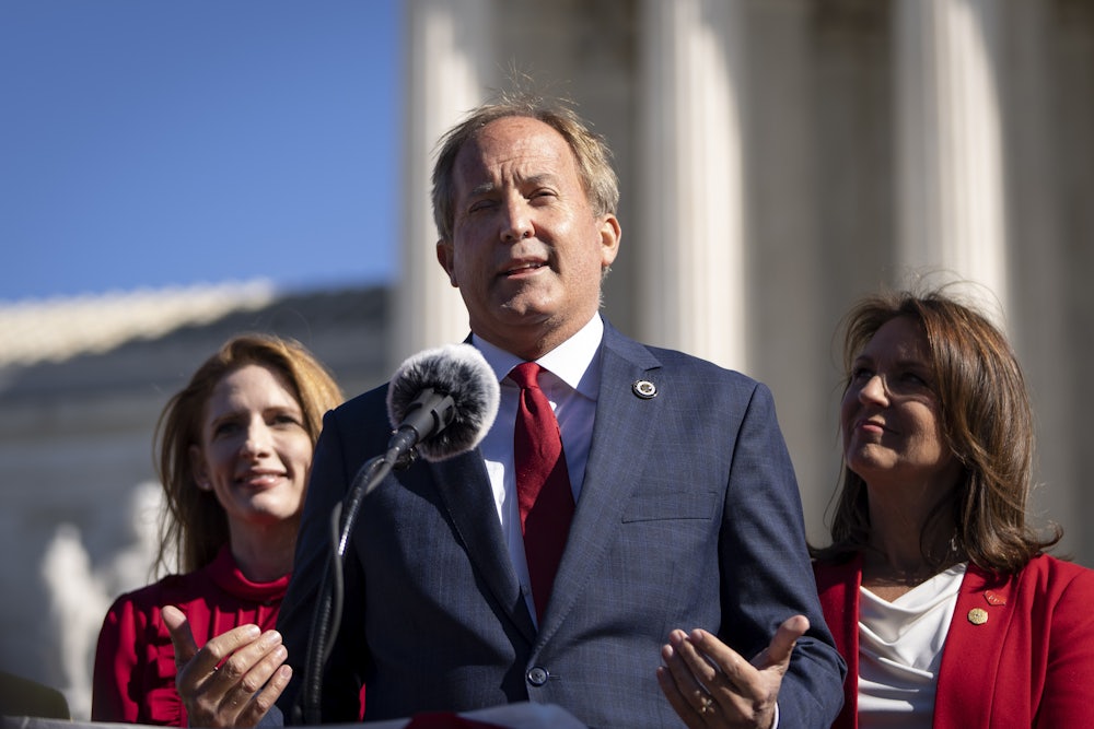 Ken Paxton speaks into a microphone.