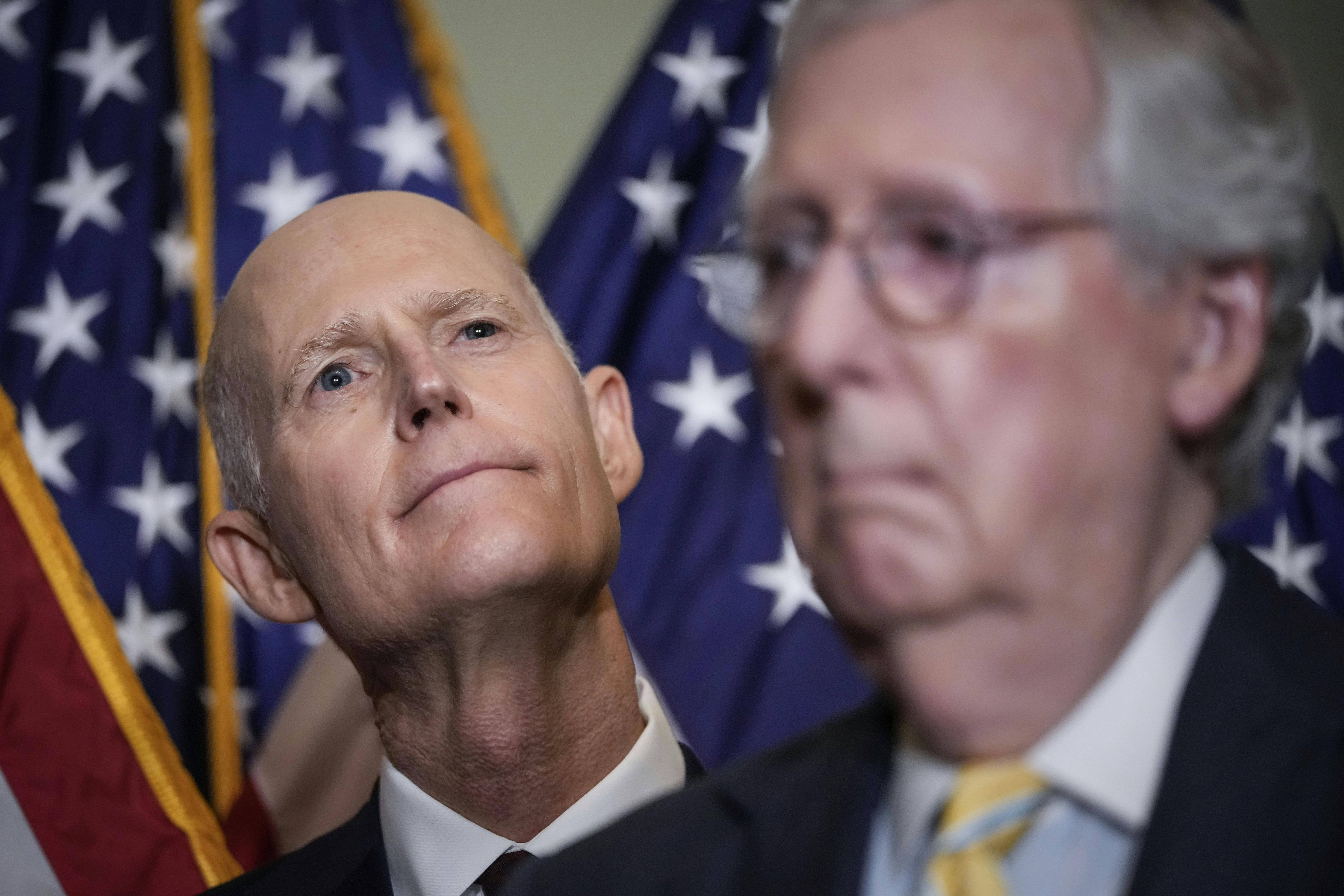 Florida Senator and NRSC chair Rick Scott stands behind Senate Minority Leader Mitch McConnell