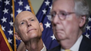 Florida Senator and NRSC chair Rick Scott stands behind Senate Minority Leader Mitch McConnell