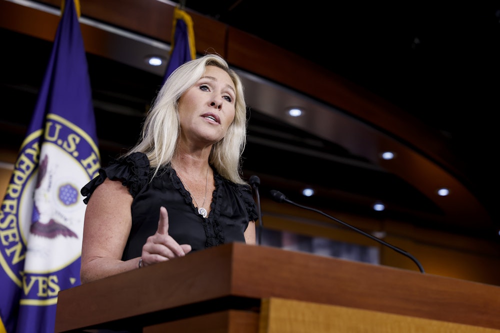 Marjorie Taylor Greene stands at a lectern.
