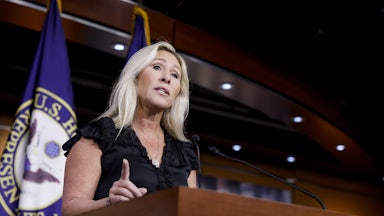Marjorie Taylor Greene stands at a lectern.