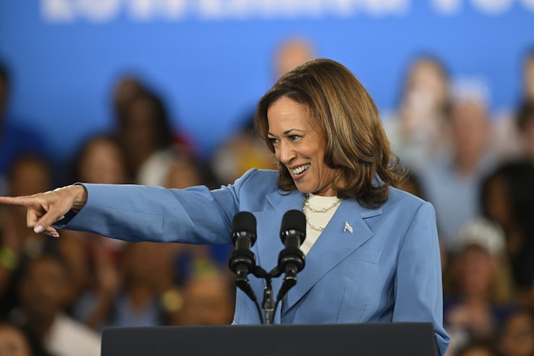 Kamala Harris smiles and points to someone in the crowd