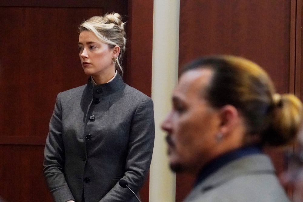 Actress Amber Heard stands as Johnny Depp re-enters the Fairfax County courtroom in which Depp's libel lawsuit is being tried.