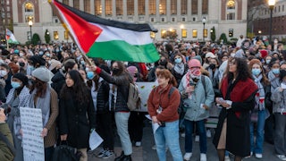 People hold protest signs and a Palestinian flag on Columbia University's campus