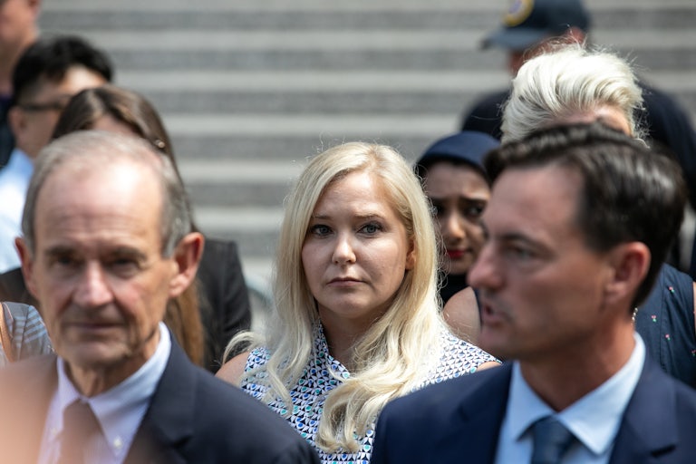 Virginia Giuffre exits federal court surrounded by other people.