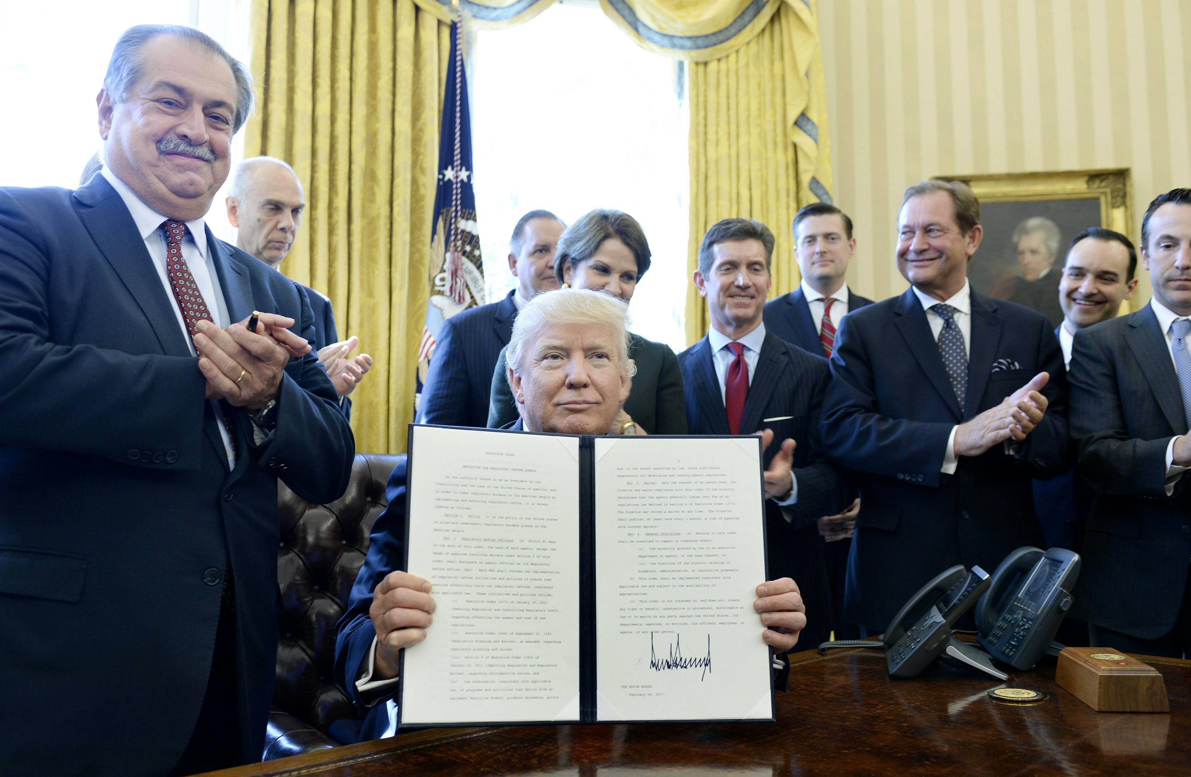 President Donald Trump flanked by business leaders