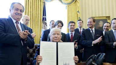 President Donald Trump flanked by business leaders