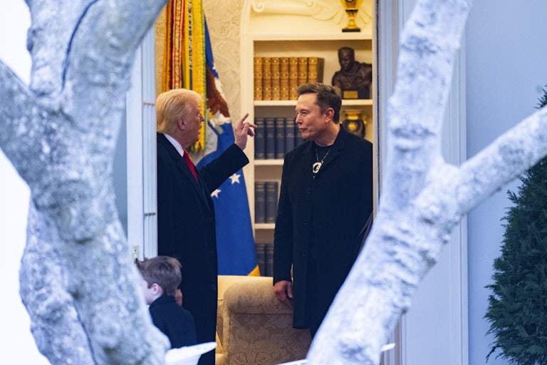Donald Trump speaks to Elon Musk in the White House as he listens.