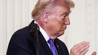 Donald Trump turns to the side and claps