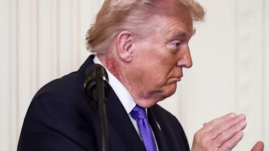 Donald Trump turns to the side and claps