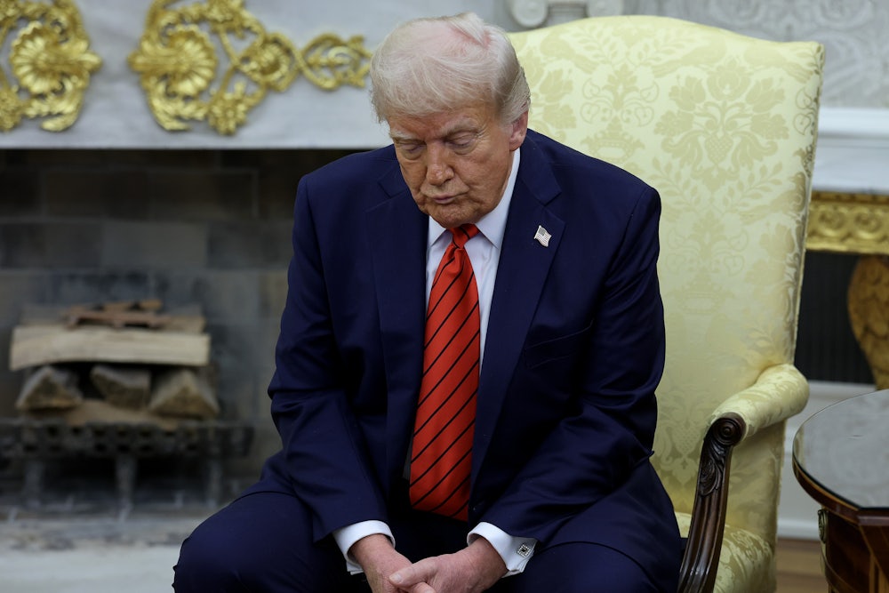Donald Trump sits slumped in a chair, forlornly looking at the floor.