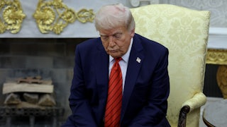 Donald Trump sits slumped in a chair, forlornly looking at the floor.