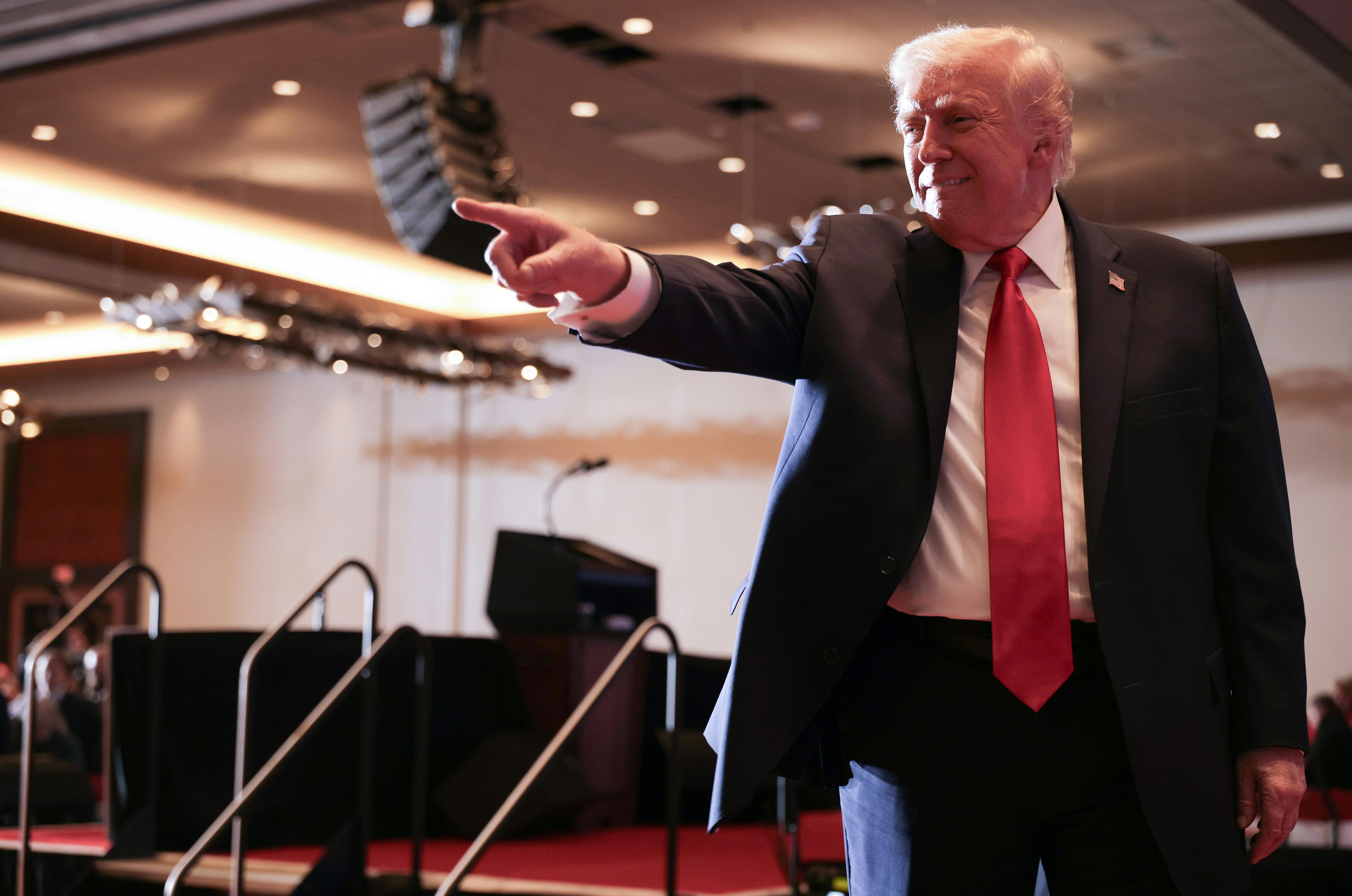 Donald Trump smiles and points to the crowd (not pictured)