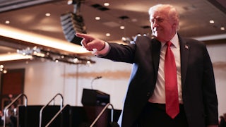 Donald Trump smiles and points to the crowd (not pictured)