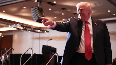 Donald Trump smiles and points to the crowd (not pictured)