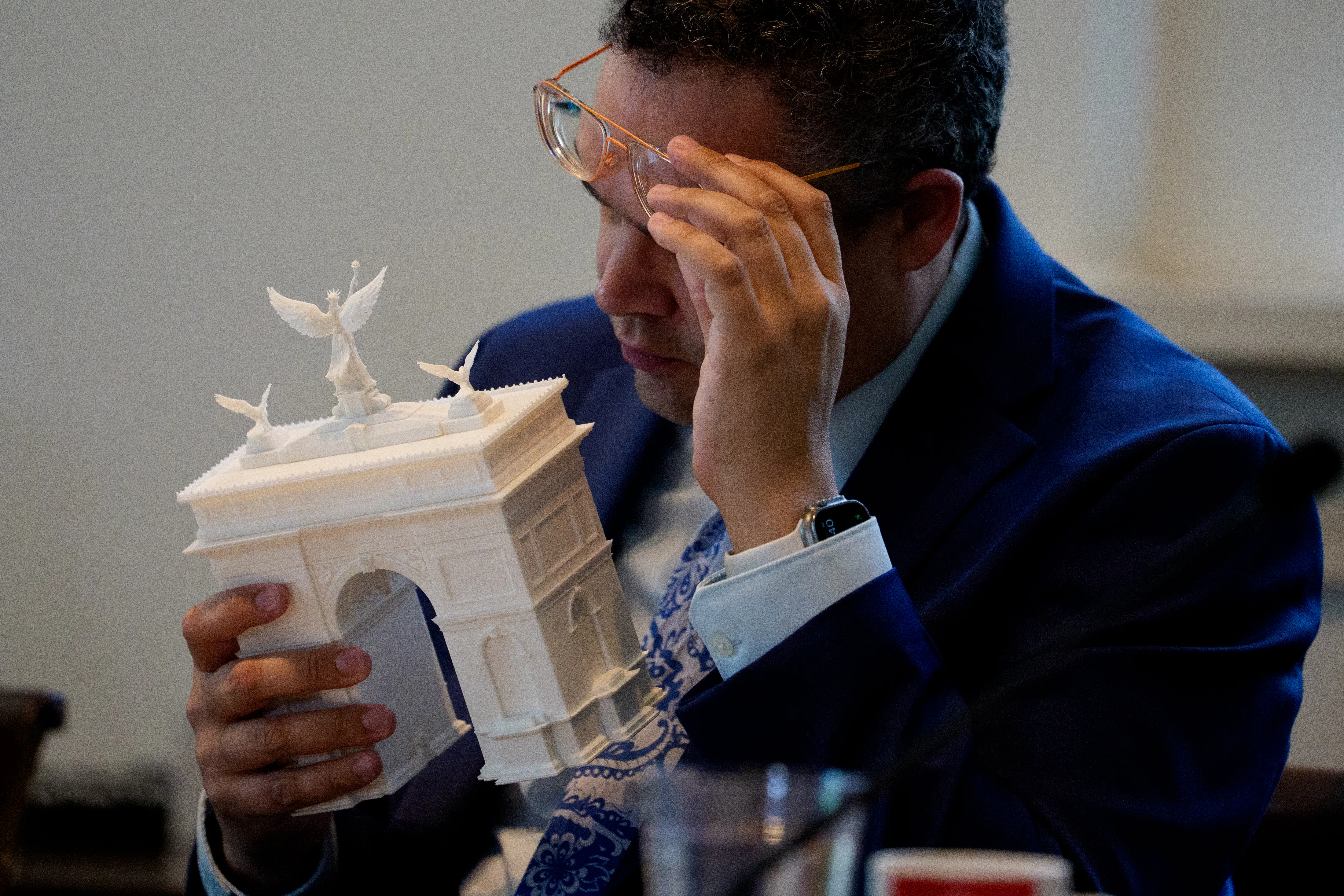 Matthew Taylor, a member of the Commission of Fine Arts, inspects a model of Trump’s proposed triumphal arch