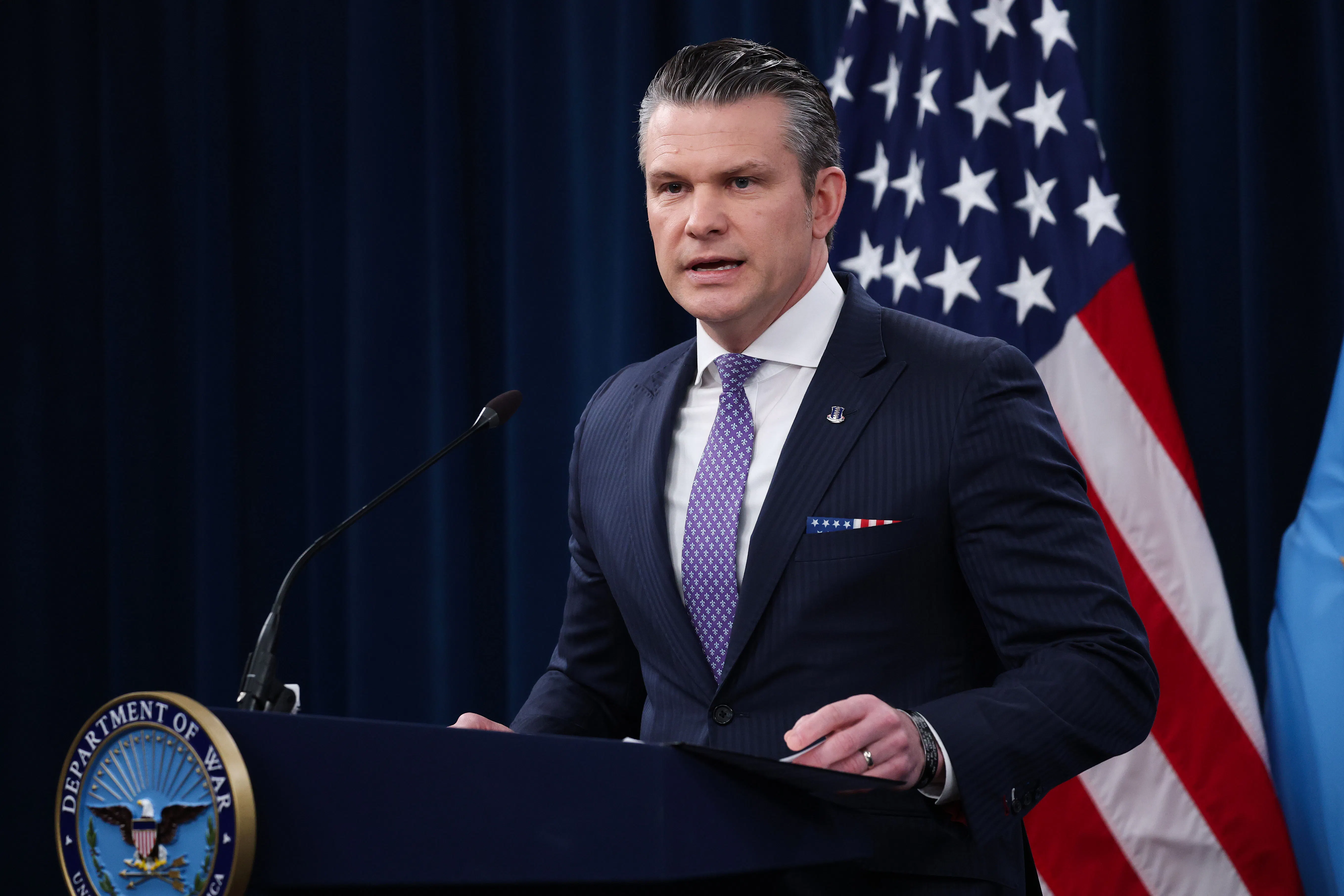 Defense Secretary Pete Hegseth stands at a podium