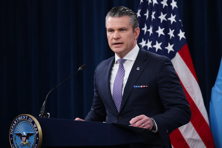 Defense Secretary Pete Hegseth stands at a podium