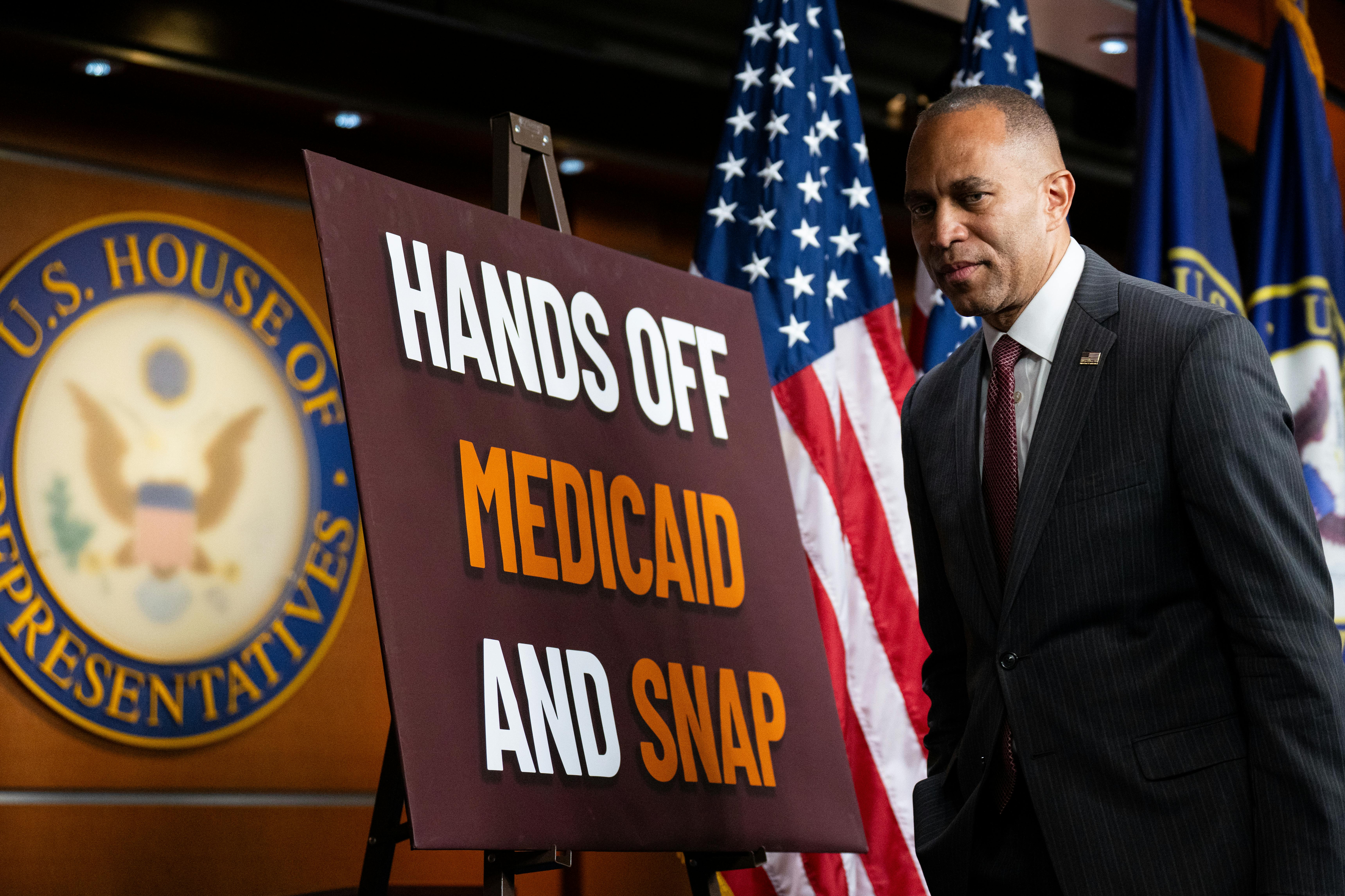 House minority leader Hakeem Jeffries strolls by a sign protesting proposed cuts to SNAP benefits that are part of the House GOP’s budget reconciliation bill.