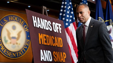 House minority leader Hakeem Jeffries strolls by a sign protesting proposed cuts to SNAP benefits that are part of the House GOP’s budget reconciliation bill.