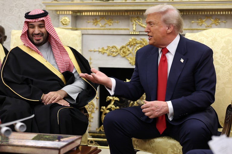 Donald Trump smiles and gestures towards Saudi Crown Prince Mohammed Bin Salman, who smiles and sits next to Trump in the Oval Office