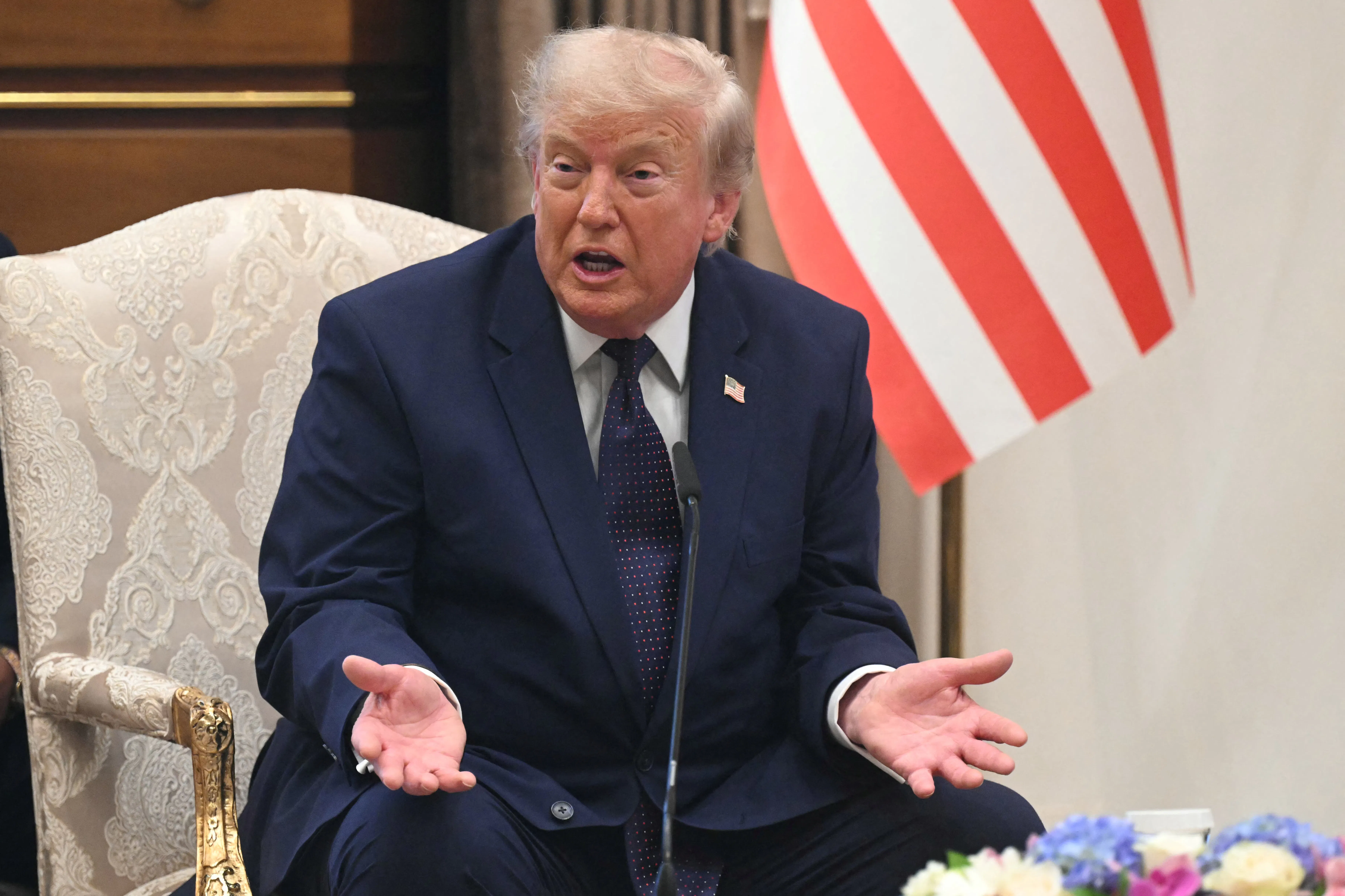 President Donald Trump speaking with his hands open on his lap