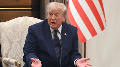 President Donald Trump speaking with his hands open on his lap