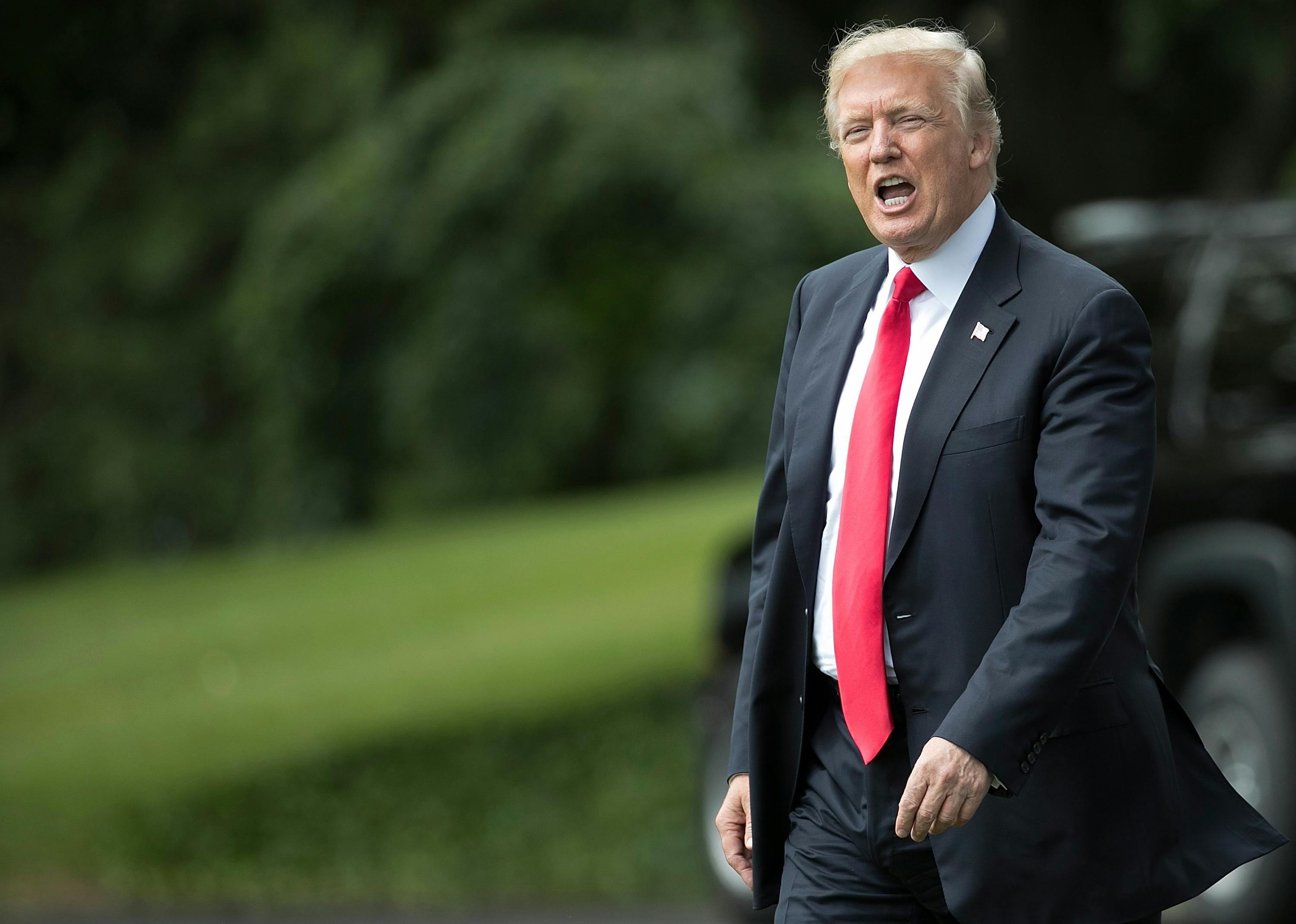 Donald Trump shouts to reporters while departing the White House.