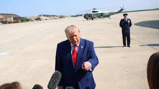 Donald Trump points while speaking to reporters before boarding Air Force One.
