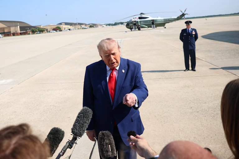 Donald Trump points while speaking to reporters before boarding Air Force One.