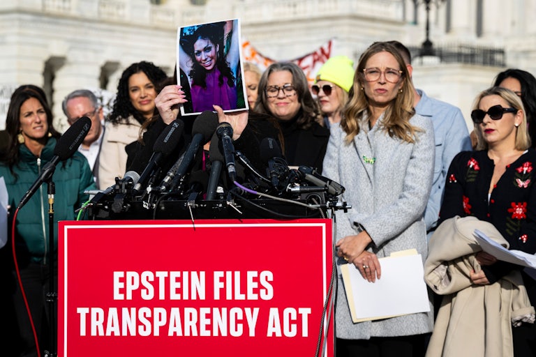 Survivors of Jeffrey Epstein's abuse stand around a podium outside the Capitol