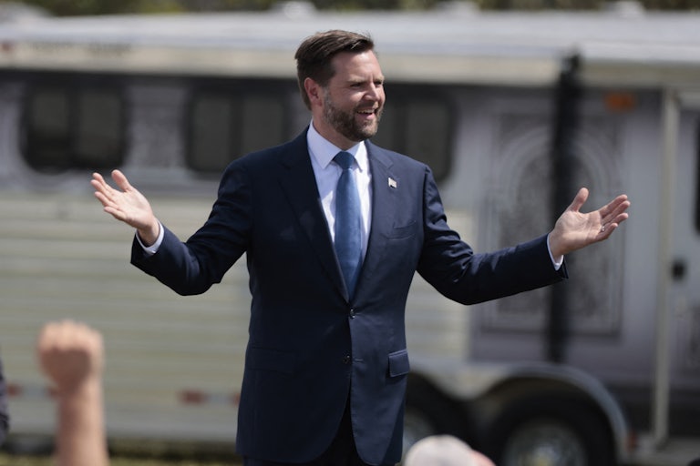 J.D. Vance holds his hands out as he walks at a Donald Trump campaign event