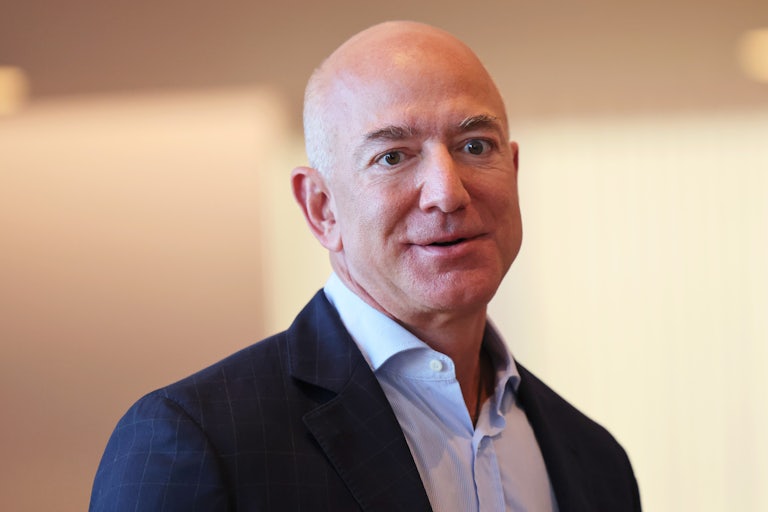 Jeff Bezos wears a navy blue blazer and light blue button up.