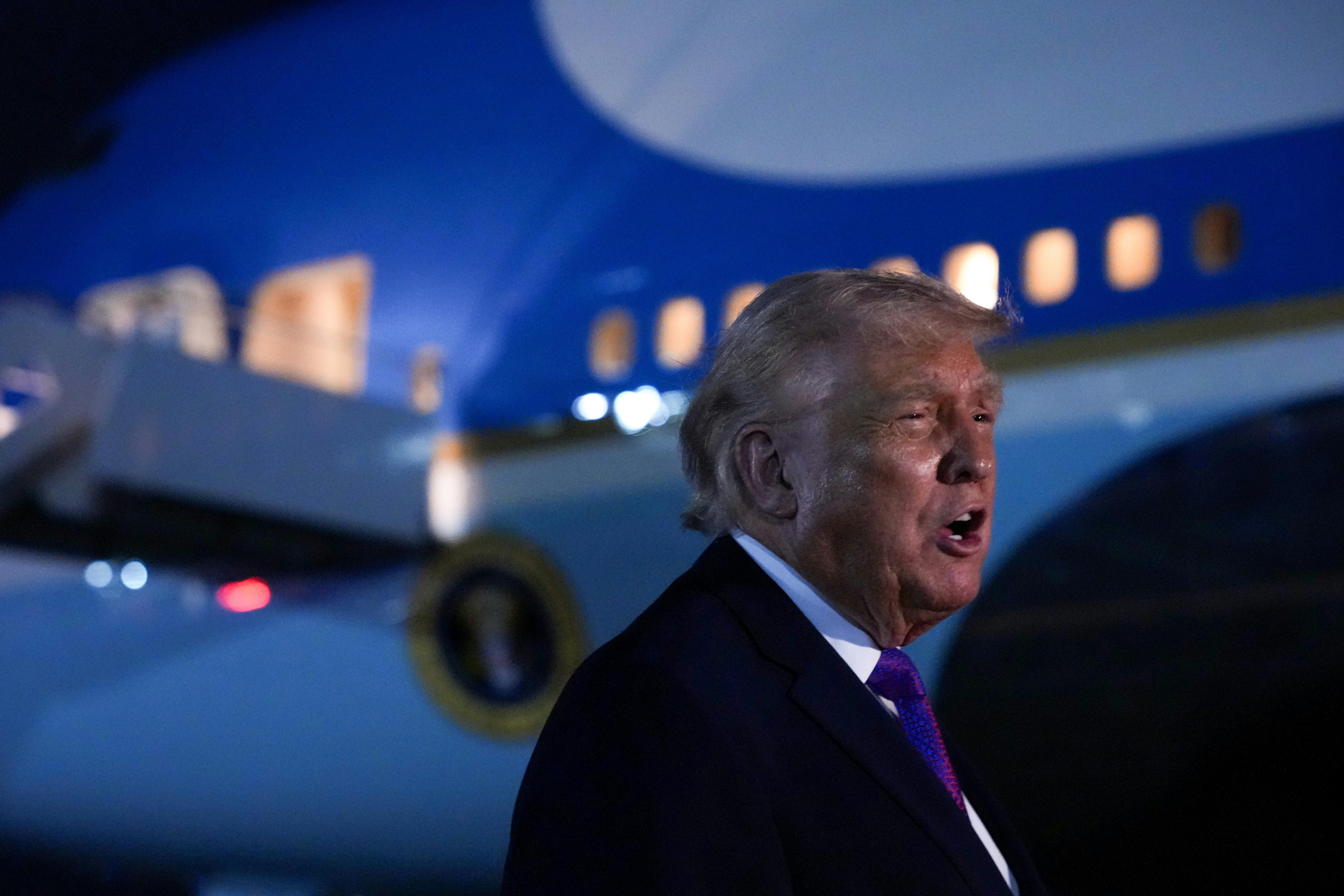 Donald Trump speaks while standing next to Air Force One