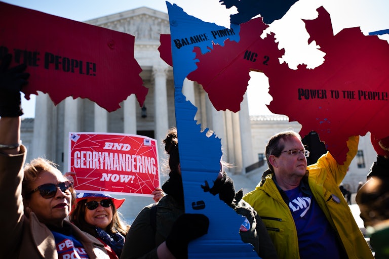 Protesters carry maps of gerrymandered districts in front of the Supreme Court.