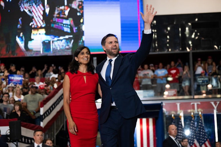 Usha and J.D. Vance stand on stage at a Donald Trump rally