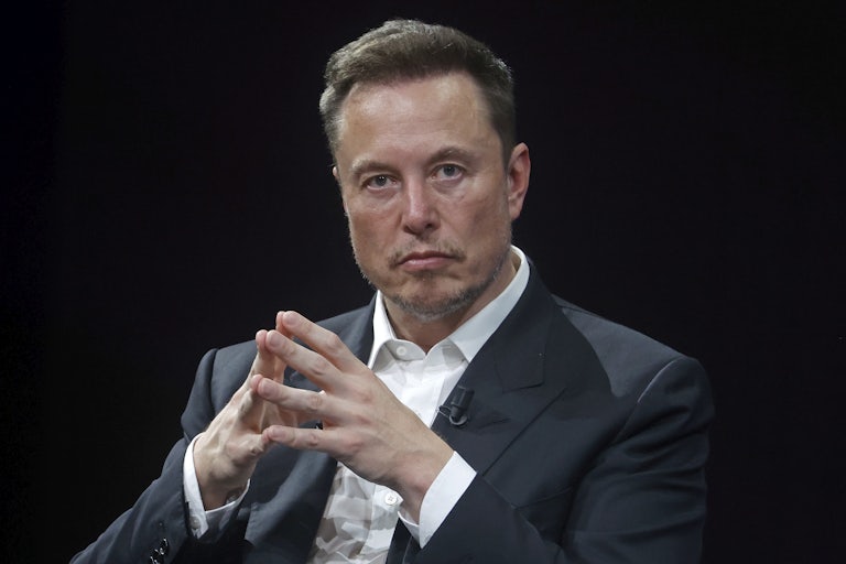 Elon Musk in folds his hands like a supervillain.