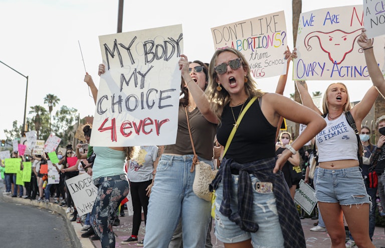 People hold up pro-abortion protest signs