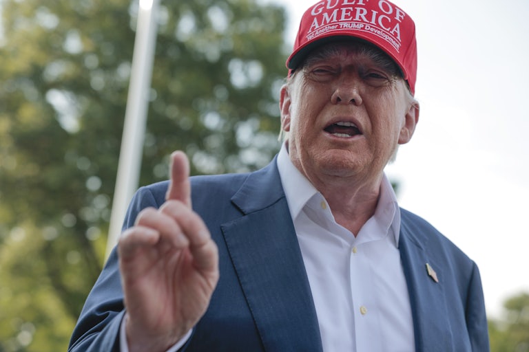 Donald Trump holds up a finger while speaking to reporters outside the White House